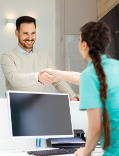 man being referred to a dentist shaking hands at front office